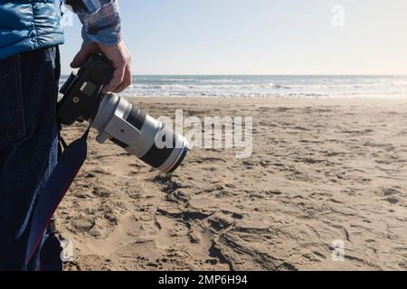 Photographer ready to take horizon photos on the beach. Professional Travel Photography Jobs. Stock Photo