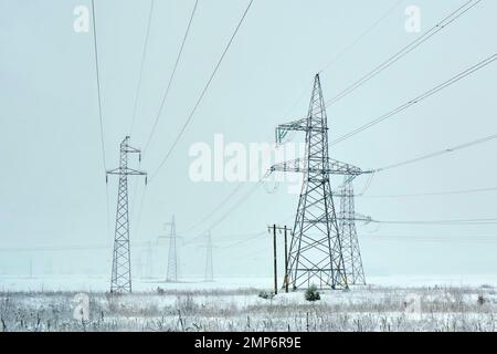 power line for industrial power transmission passing through the field electricity wires megawatts metal tower construction Stock Photo