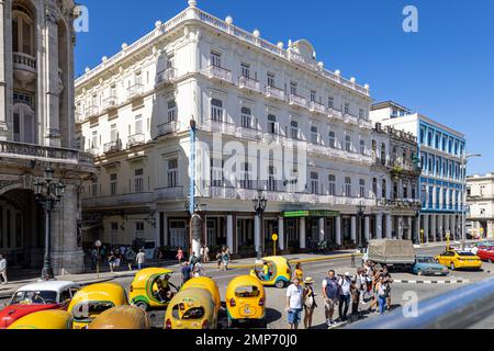 Yellow Coco tuk tuk taxis outside Hotel Inglaterra, Paseo de Marti, Central Havana Stock Photo