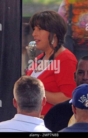 Adam Sandler, 44, shows off his smoothly shaven legs in a plaid skirt paired with a white top, red cardigan and red open-toed shoes as he films scenes for his new comedy 'Jack and Jill.' Dressed in full drag, Sandler even donned a brunette wig styled into braids and painted fingernails as he played the role of Jill during filming. In the film, Sandler also plays the character of Jack, who is forced to deal with his twin sister, Jill, when she visits for Thanksgiving and refuses to leave. Also starring in the film are Katie Holmes, who plays Jack's wife and Al Pacino who makes a cameo appearanc Stock Photo