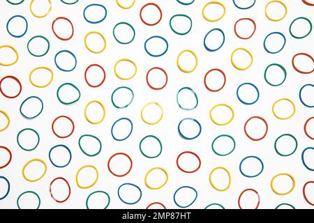 Flat lay colourful rubber band background. Office supply, elastic band. Many circles on white background, abstract pattern. Stock Photo