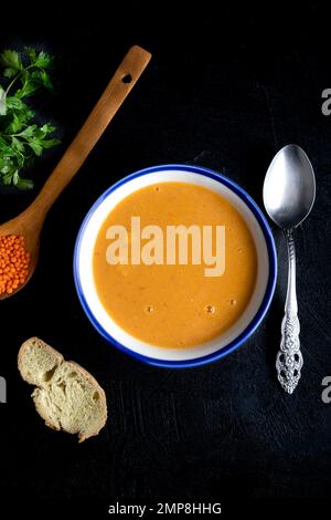 Red lentil soup puree in a bowl  n dark background. Traditional middle eastern cuisine. Vegan food. Stock Photo