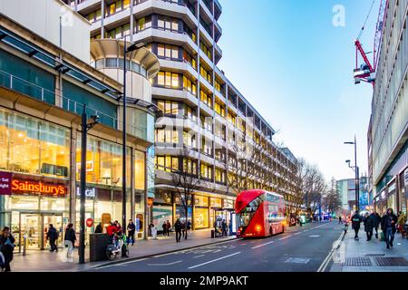 A view along Tottenham Court Road in London, UK in early evening with lights from shops and offices lighting the scene. Stock Photo