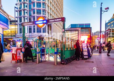 An entrance with stairs leading down into Tottenham Court Road London Underground Station lit up as it starts to go dark in the evening. Stock Photo