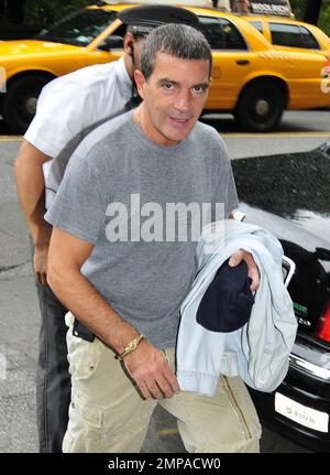 EXCLUSIVE!! Actor Antonio Banderas heads for the airport as he leaves his apartment. The busy actor is currently starring in two films, one, 'The Skin I Live In' is directed by his friend Pedro Almodovar and is a 'cold' horror film in which he plays a quietly twisted scientist who keeps a beautiful woman locked in his home. The second, 'Puss In Boots,' is an animated feature based upon Banderas' character from the popular 'Shrek' series. New York, NY. 14th October 2011. Stock Photo