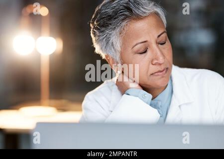 Night, stress and neck pain with doctor at laptop for medical, thinking and deadline review. Burnout, accountability and mental health with senior Stock Photo