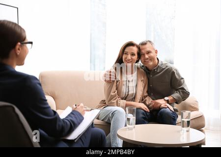 Psychotherapist and happy couple having meeting in office. Family counselling Stock Photo