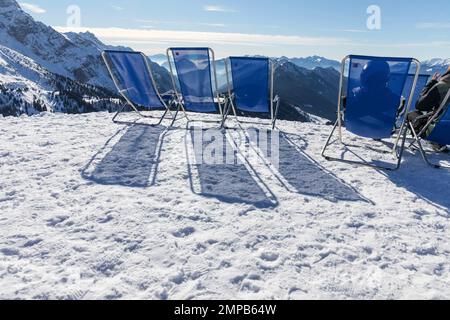 Sunbeds with a view of the Pinzolo valley. Inversion and fog over the ski area of Pinzolo (TN) Italy. A view from above of a fog-covered valley. Super Stock Photo