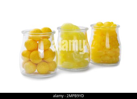 Different tasty lemon drops in jars isolated on white Stock Photo