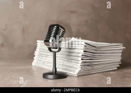 Newspapers and vintage microphone on marble table. Journalist's work Stock Photo