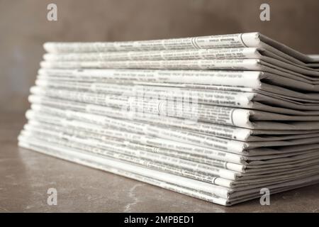 Stack of newspapers on marble table, closeup. Journalist's work Stock Photo