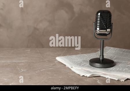 Newspapers and vintage microphone on marble table, space for text. Journalist's work Stock Photo