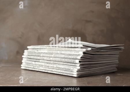 Stack of newspapers on marble table. Journalist's work Stock Photo