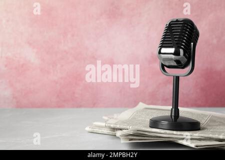 Newspapers and vintage microphone on table, space for text. Journalist's work Stock Photo
