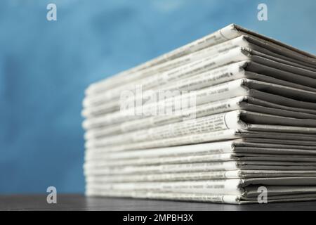 Stack of newspapers on blue background, closeup. Journalist's work Stock Photo