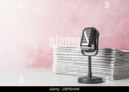 Newspapers and vintage microphone on table, space for text. Journalist's work Stock Photo