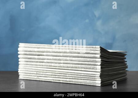 Stack of newspapers on blue background. Journalist's work Stock Photo