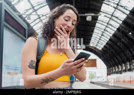 Young freelance business woman traveler of Argentinian ethnicity is very happy surprised checking her daily earnings from her digital business on the Stock Photo