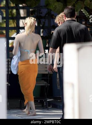 Exclusive!! Avril Lavigne takes a dip in the pool with a cocktail in hand as hubby Deryck Whibley watches on. Avril showed off her rocking body in a baby blue bikini. Miami, FL. 1/30/08. Stock Photo