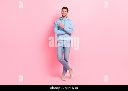 Full length size photo of cheerful dreaming direct finger looking empty space new showroom clothes brand opening isolated on pink color background Stock Photo