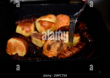 Christmas Roast Potatoes, Sausages, cooked and ready to eat. 2022. Stock Photo