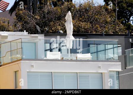 Here are exterior views of the luxury Santa Monica beachfront home where the Beckham's spent a sun-filled weekend with pals. The $5 million three story white dream home was the perfect spot for David, Victoria and their sons to relax and play without spending any more of their fortune. The Beckham's are reported to have recently cut their outgoings by releasing several members of their staff. The group, which included Gordon Ramsay, his wife Tana and their children,  were seen lounging on one of the home's three balconies, where Victoria sipped wine, tanned and smoked a cigar.  The sunny water Stock Photo