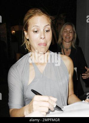 Maria Bello wears a grey slinky dress and appears to go braless