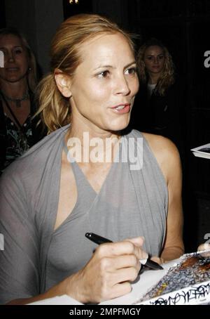 Maria Bello wears a grey slinky dress and appears to go braless outside