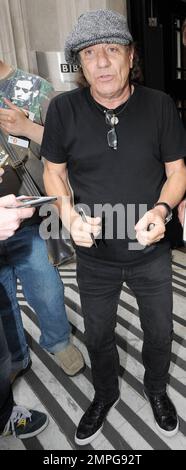 EXCLUSIVE!! Lead singer for the legendary rock band AC/DC Brian Johnson signs autographs for waiting fans outside BBC Radio studio.  Johnson peered out from under his grey drivers cap and smiled for the camera.  When asked if he'd pose beside BBC Radio 2 DJ Chris Evans' new Ferrari he reportedly said jokingly, 'With all due respect, why would I want to pose in front of someone else's car? I just bought a new Ferrari today.' London, UK. 07/29/10. Stock Photo