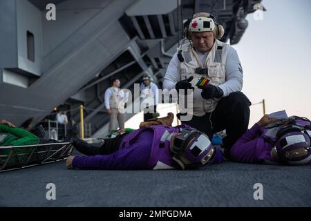 Hospital Corpsman 2nd Class Jack Hautala, from Ely, Minnesota, assigned to the first-in-class aircraft carrier USS Gerald R. Ford's (CVN 78) medical department, provides emergency medical care to a simulated victim during a mass casualty drill on the ship's aircraft elevator, Oct. 14, 2022. The Gerald R. Ford Carrier Strike Group (GRFCSG) is deployed in the Atlantic Ocean, conducting training and operations alongside NATO Allies and partners to enhance integration for future operations and demonstrate the U.S. Navy’s commitment to a peaceful, stable and conflict-free Atlantic region. Stock Photo