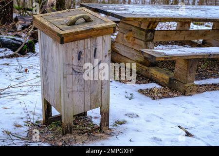 A wooden waste bin in nature. Clean environment in nature. Urn with opening lid. Stock Photo