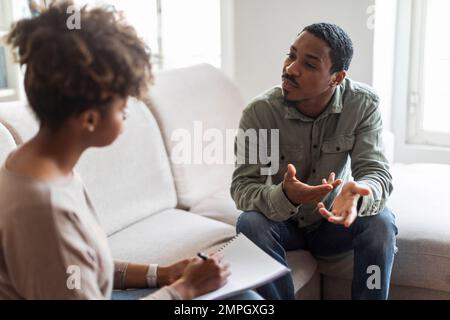 Confused black guy sharing thoughts with psychologist Stock Photo