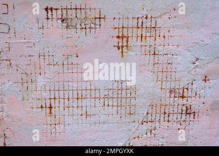 Rough concrete wall background with rusty wire rebar. Damaged wall background. Stock Photo