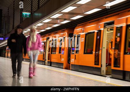 Blurred motion of people leaving orange metro train in Hakaniemi metro station, Helsinki, Finland Stock Photo