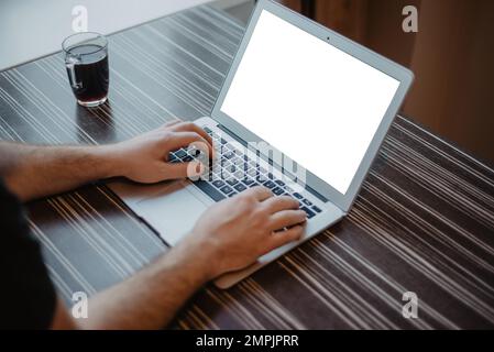 Business man working on laptop computer at the desk. Laptop screen mockup. Stock Photo