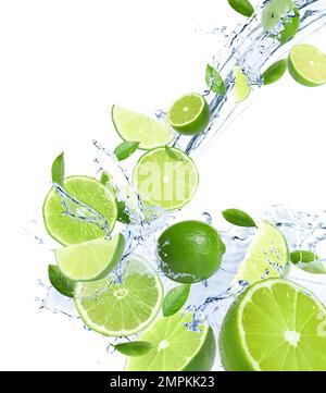 Ripe limes, fresh mint and splashing water on white background Stock Photo