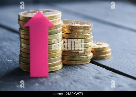 Stacks of gold coins with arrow. Stock Photo