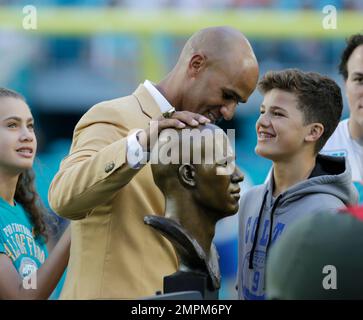 Former Miami Dolphins player Jason Taylor goes to kiss his wife, Katina, as  he and Zach Thomas are inducted into the Dolphins' Ring of Honor during  halftime of the game between the