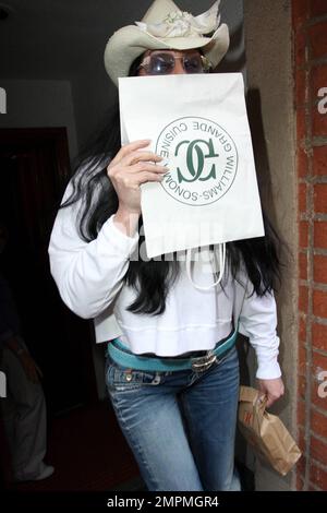 Cher hides her face with a paper bag as she leaves a medical building with a pharmaceutical package.  While Cher, 63, managed to keep her face from view she however wasn't able to hide the liver spots on her hands. Los Angeles, CA. 03/24/10.      . Stock Photo