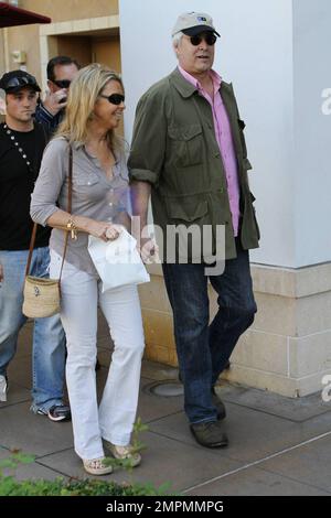 Veteran actor Chevy Chase holds hands with his wife Jayni Chase as they walk around The Grove shopping center where Chevy joined the American TV show 'Extra' for an interview.  Jayni, who has been married to Chevy for 28 years, looked very happy as she held a small Nordstrom bag. Los Angeles, CA. 10/07/10. Stock Photo