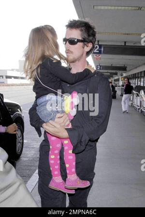Actor Christian Bale carries his daughter Emmeline as he arrives with