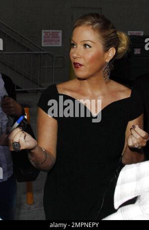 Wearing a simple black dress and sporting a short ponytail, Christina Applegate signs autographs for fans outside the 'Jimmy Kimmel Live!' studios where she made an appearance to promote her new film 'Cats and Dogs: Revenge of Kitty Galore.' Los Angeles, CA. 7/27/10. Stock Photo