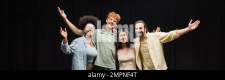 troupe of smiling multicultural actors hugging and waving hands in theater, banner Stock Photo