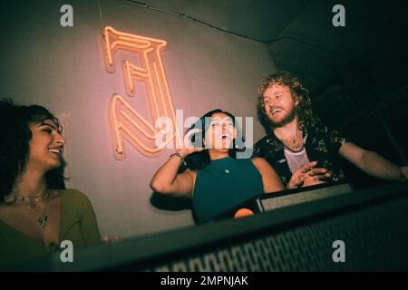 Happy young female DJ dancing amidst friends while enjoying weekend at nightclub Stock Photo