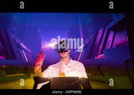 Young businessman gesturing while wearing virtual reality simulator at workshop Stock Photo