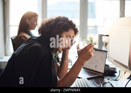 Tired businesswoman with head in hand holding drinking glass at office Stock Photo