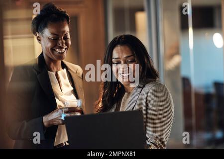 Happy business colleagues working on laptop at office Stock Photo