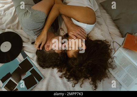 Directly above view of romantic couple rubbing noses while lying on bed at home Stock Photo