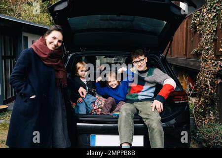 Happy family with electric car enjoying together in back yard Stock Photo
