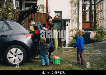 Family loading stuff in electric car while preparing for picnic Stock Photo